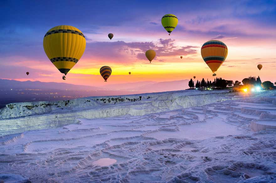 Hot air balloons in the sky above Pamukkale hot springs