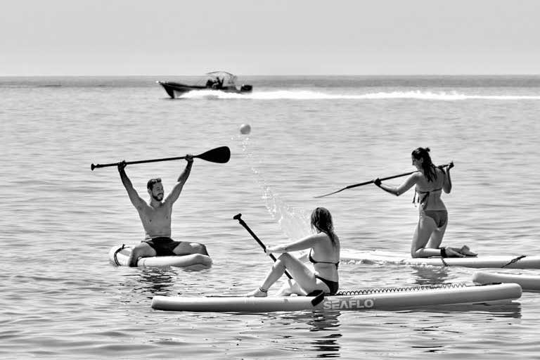 three people surfboarding near Dhermi beach