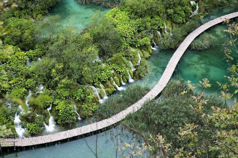 wooden path crossing Plitvice lakes, surrounding the waterfalls