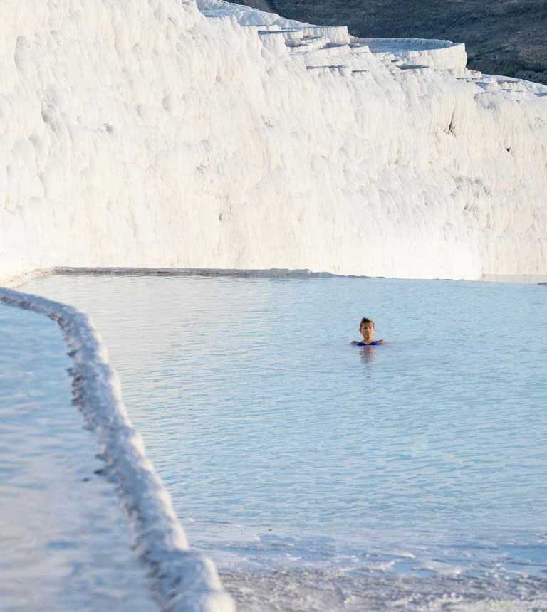 a woman soaking in Pamukkale thermal pools