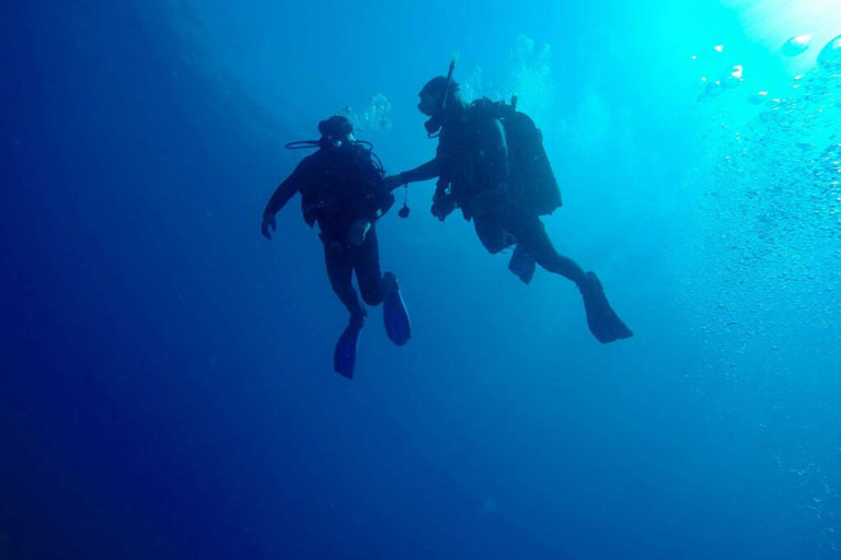 Two scuba divers diving in Gjipe beach cave
