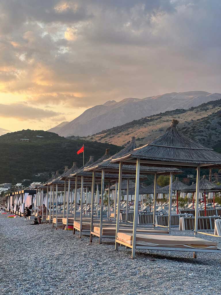 pebble beach in Himare with sunbeds